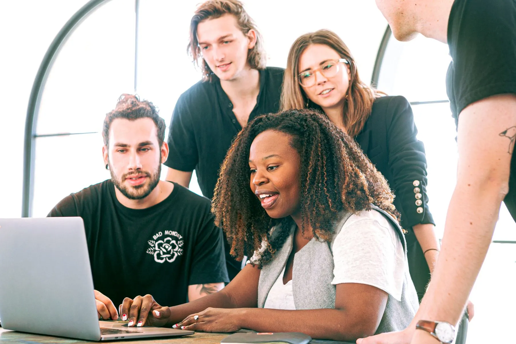 Colleagues smiling while working together on a laptop